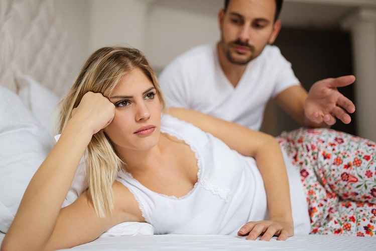 girl and guy on bed arguing