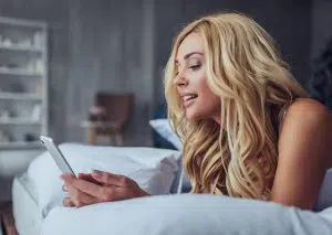 girl texting on phone in bed